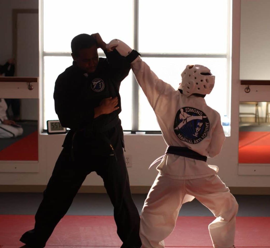 young taekwondo student sparring with instructor